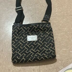 A Tommy Hilfiger purse with adjustable straps and tan patterns on the outside